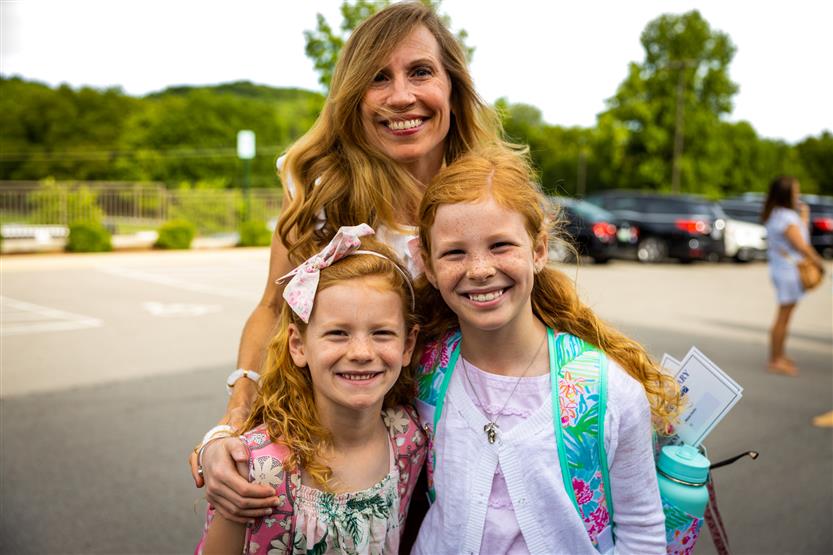 Two girls and their mother smile